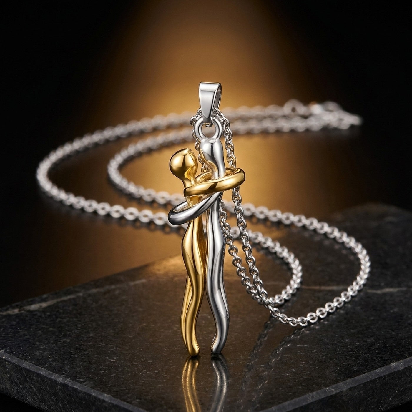 Collar Abrazo Eterno: dos figuras abrazadas en dorado y plateado
